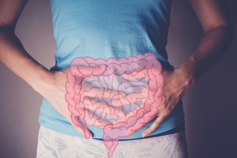 woman's hands on stomach with diagram of intestines