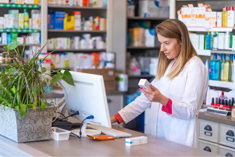 female pharmacist looking up prescription on the computer