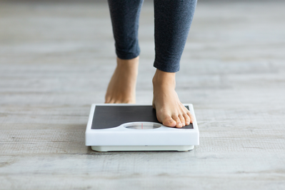 close up of woman's feet stepping onto a scale