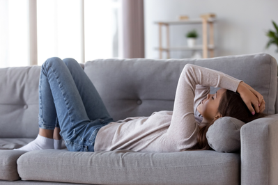 tired young woman lying on couch