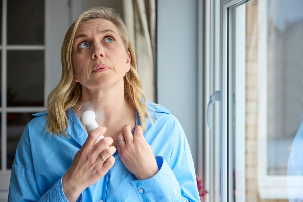 menopausal woman fanning neck during hot flash